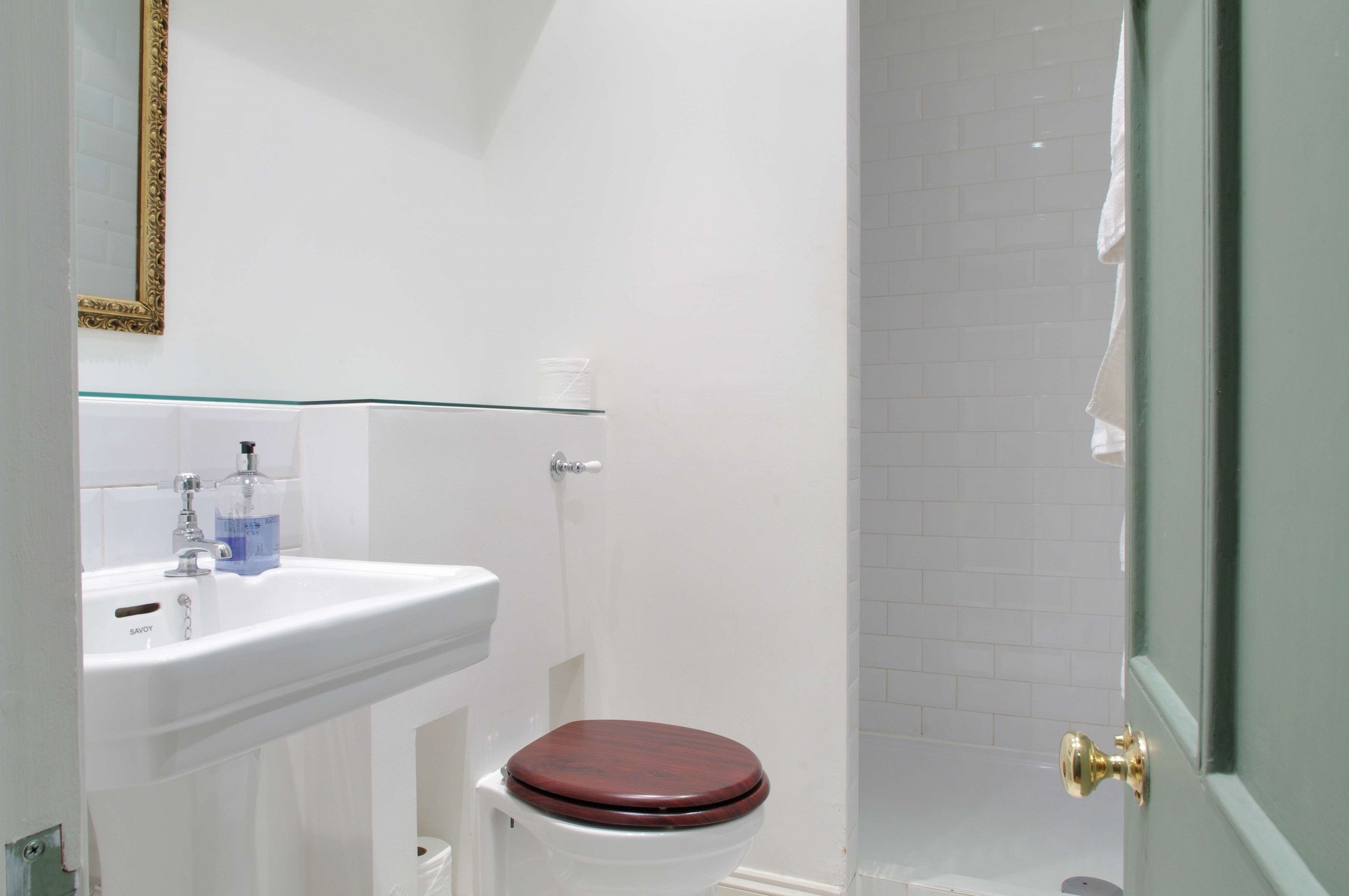 A bathroom with a white sink, a toilet, and a shower area.