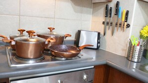 A kitchen with stainless steel appliances, including a stove, pots, a toaster, and a knife rack. - Chile4Rent Eleuterio Ramirez (Santiago)