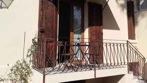 A balcony with a wrought iron railing, wooden shutters, and a bottle of wine on the windowsill. - Verona4rent Roberto (Verona)
