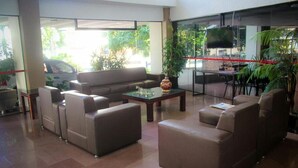 Un'ampia hall con un divano, un tavolino da caffè e una televisione.