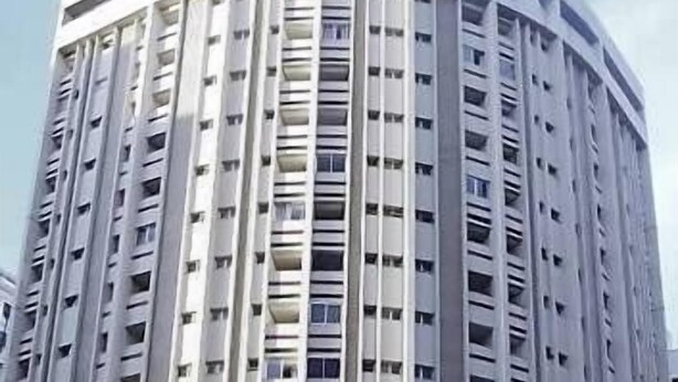 Un edificio alto e cilindrico con numerosi balconi e finestre.
