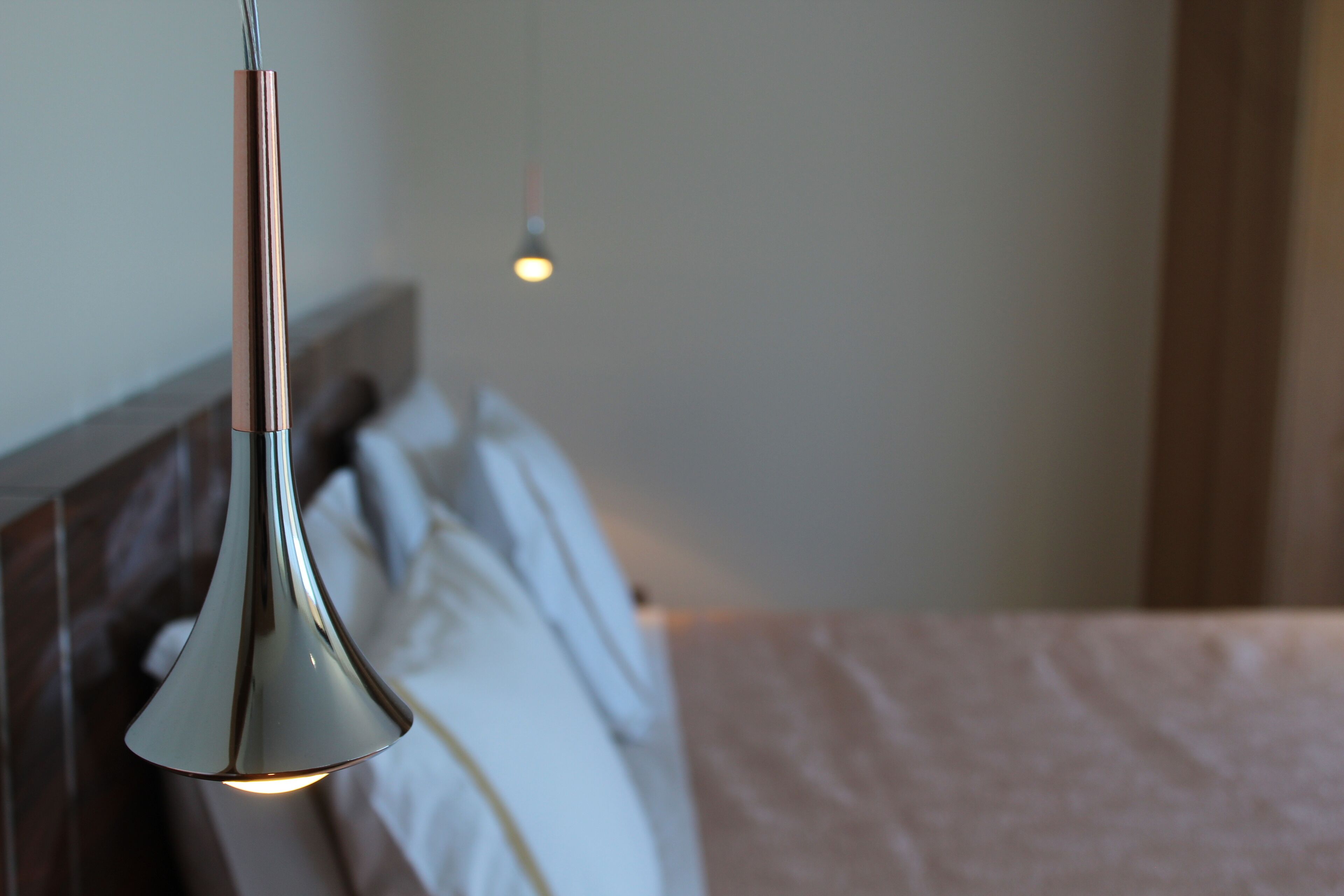 Una cama moderna con cabecera de madera y ropa de cama blanca.