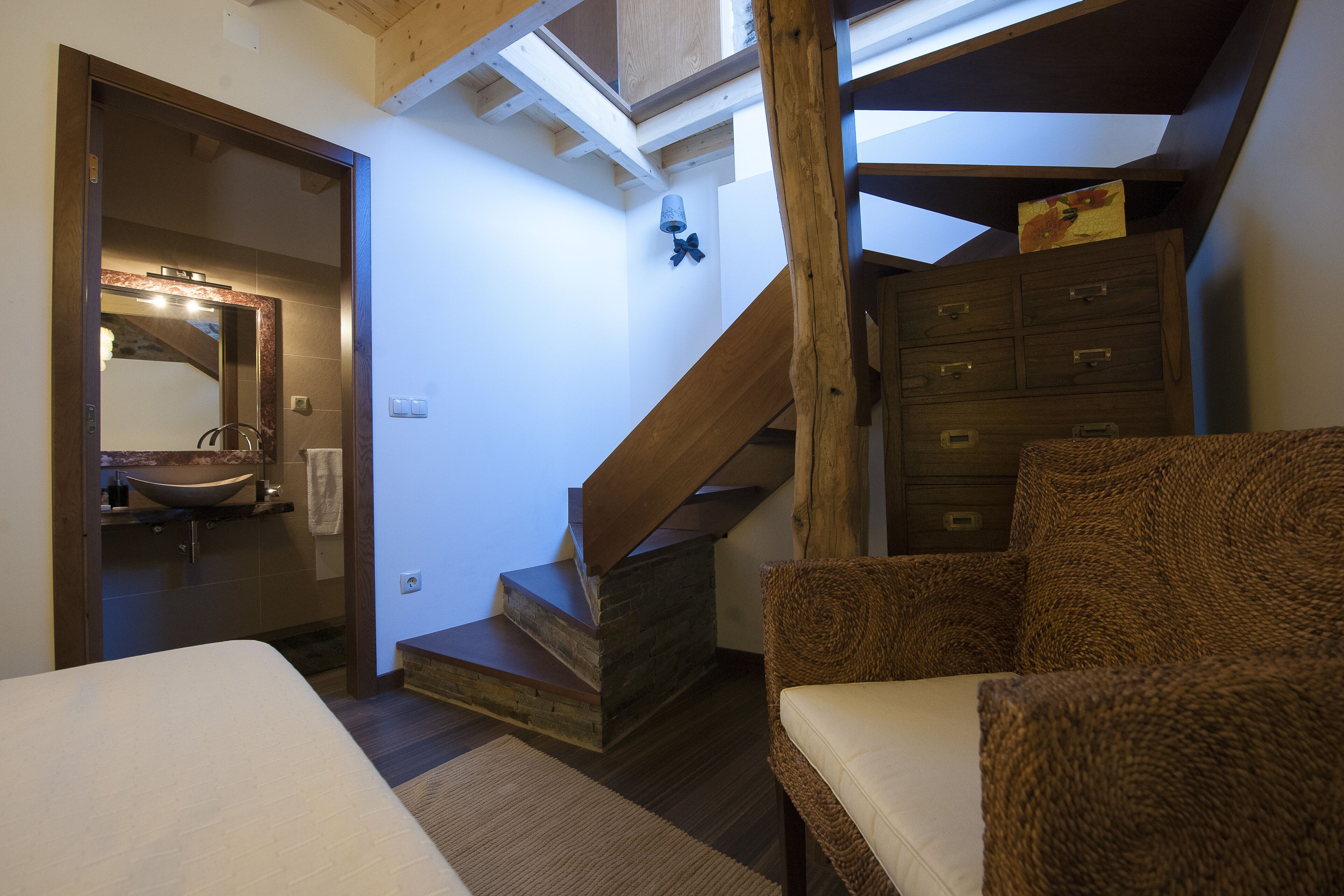 Un dormitorio con una escalera de madera, un gran aparador de madera y una cama.