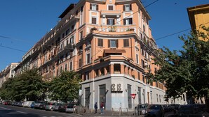 A multi-story building with a corner entrance, large windows, and balconies.