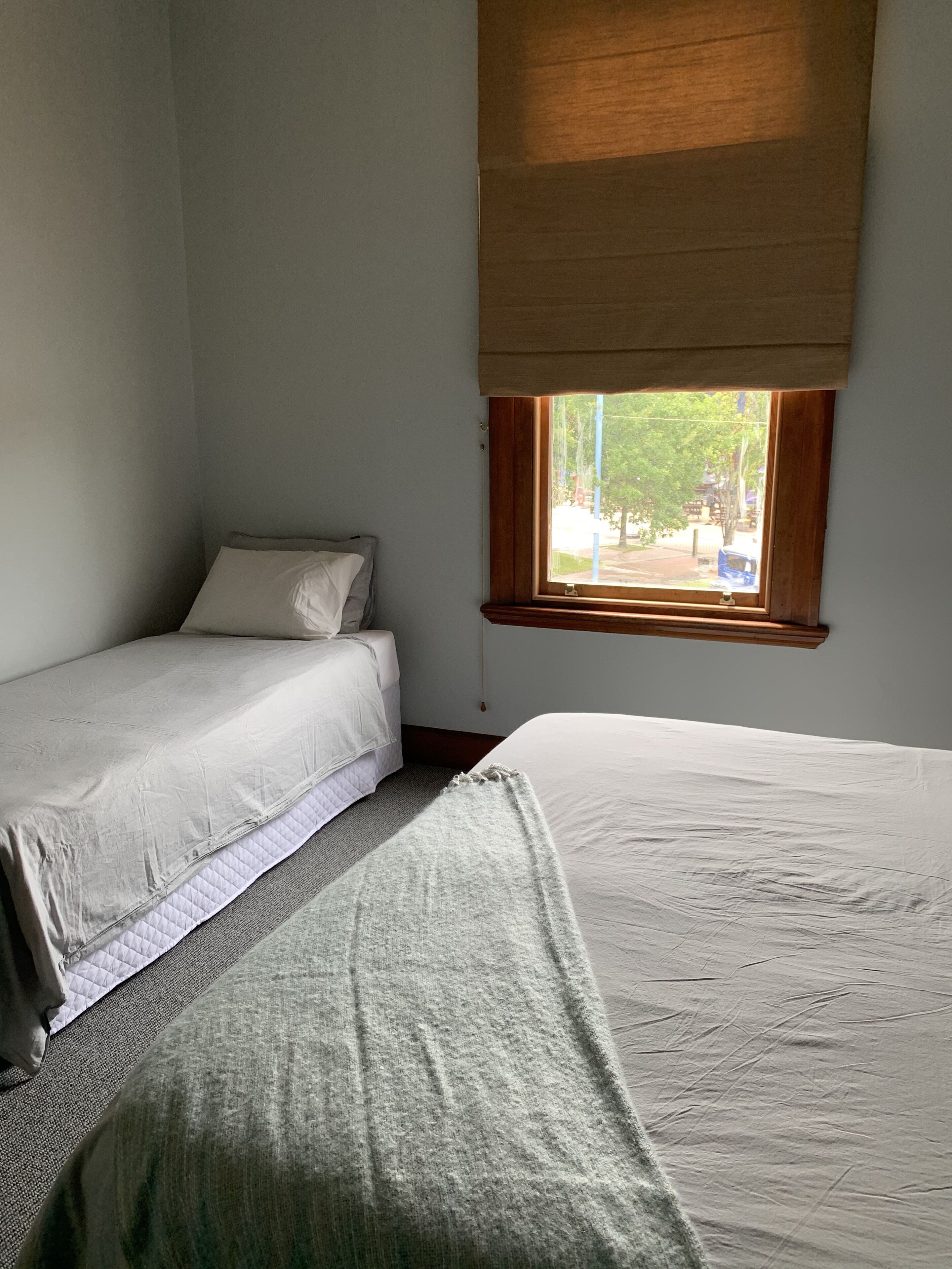 Une chambre avec deux lits, une fenêtre donnant sur l’extérieur et un plafond en bois.