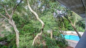 A poolside area with trees and a concrete structure overhead. - Amelia Landings Condo, Easy Access to the Pool and Short Walk to the Beach by RedAwning (Fernandina Beach)