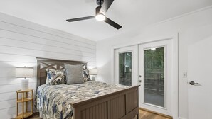A bedroom with a bed, a ceiling fan, a nightstand, and a window with blinds. - Amelia Landings Condo, Easy Access to the Pool and Short Walk to the Beach by RedAwning (Fernandina Beach)