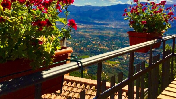 A balcony with red flowers and a view of a valley. - Bed & Breakfast Selvaggio Blu (Baunei)