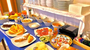 A buffet table with various food items including fruits, pastries, and condiments. - Bed & Breakfast Selvaggio Blu (Baunei)