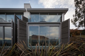 Una casa moderna con ventanas amplias y vistas a la montaña.