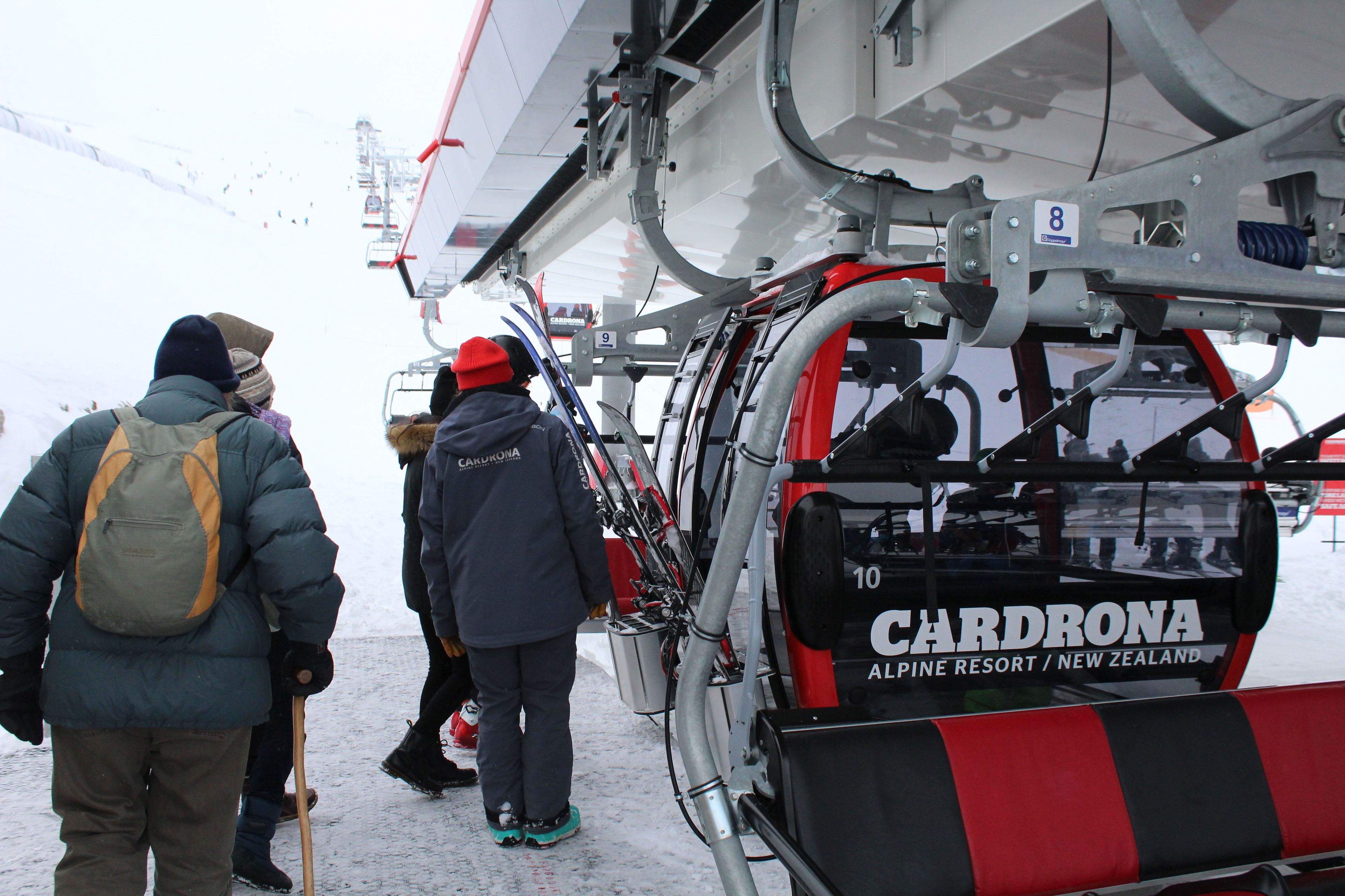 A ski lift with passengers, labeled "CARDRONA ALPINE RESORT / NEW ZEALAND."