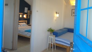 Un dormitorio con cama, mesita de noche y una planta pequeña.