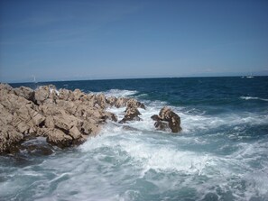 A rocky coastline with waves crashing against the rocks.