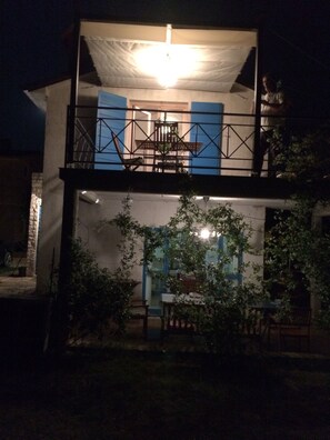A two-story building with a balcony and a dining area.
