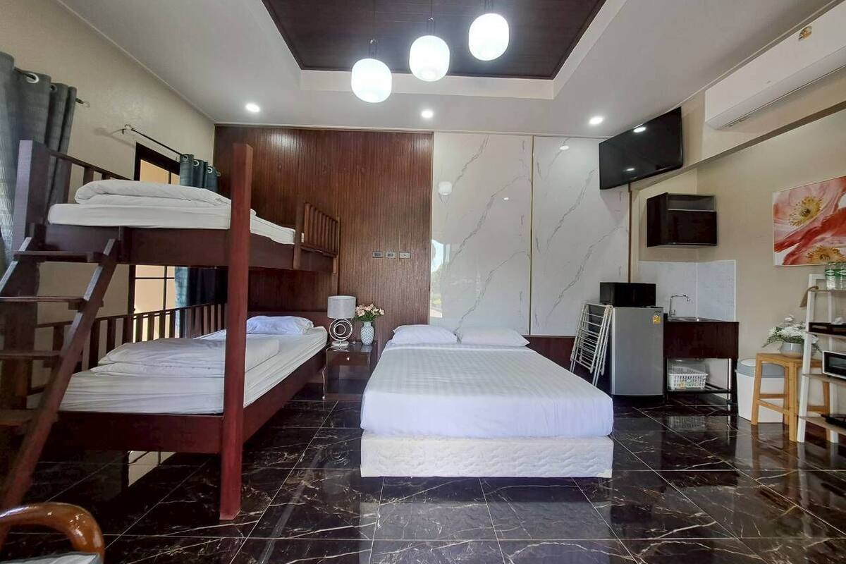 A hotel room with two beds, a TV, a desk, and a chair.