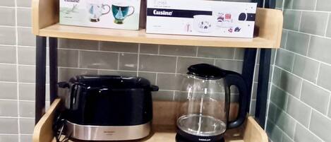 A kitchen shelf with kitchenware boxes, a coffee maker, and a dish rack.