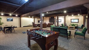 A spacious indoor area with a foosball table, comfortable seating, and a television. - Snowline Lodge Condo #9 (Deming)