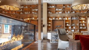 A modern interior with a fireplace, bookshelves, and seating areas. - Omni Louisville Hotel (Louisville)