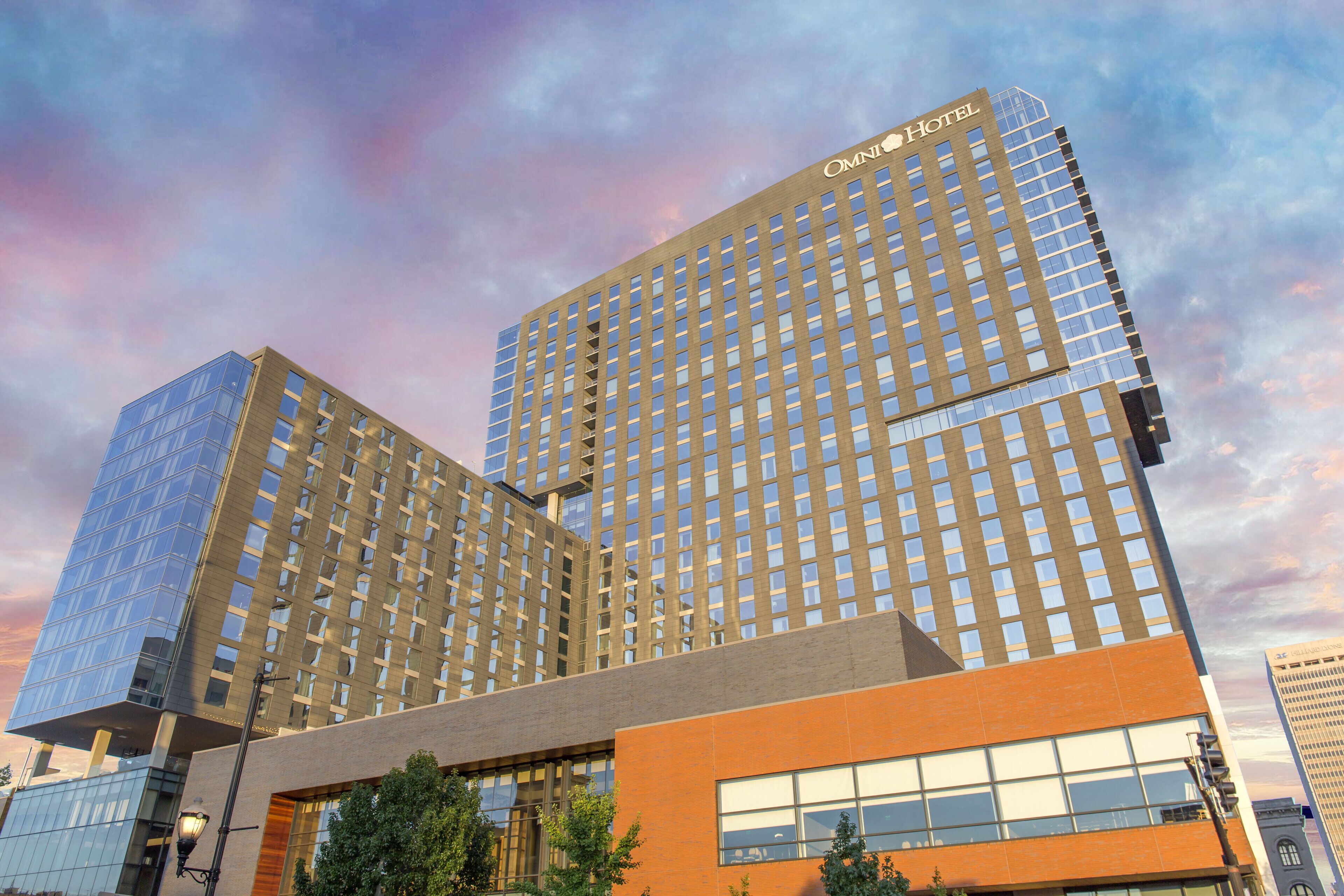 A hotel with a modern architectural design, featuring multiple high-rise buildings with reflective glass facades and a prominent orange section at the base.
