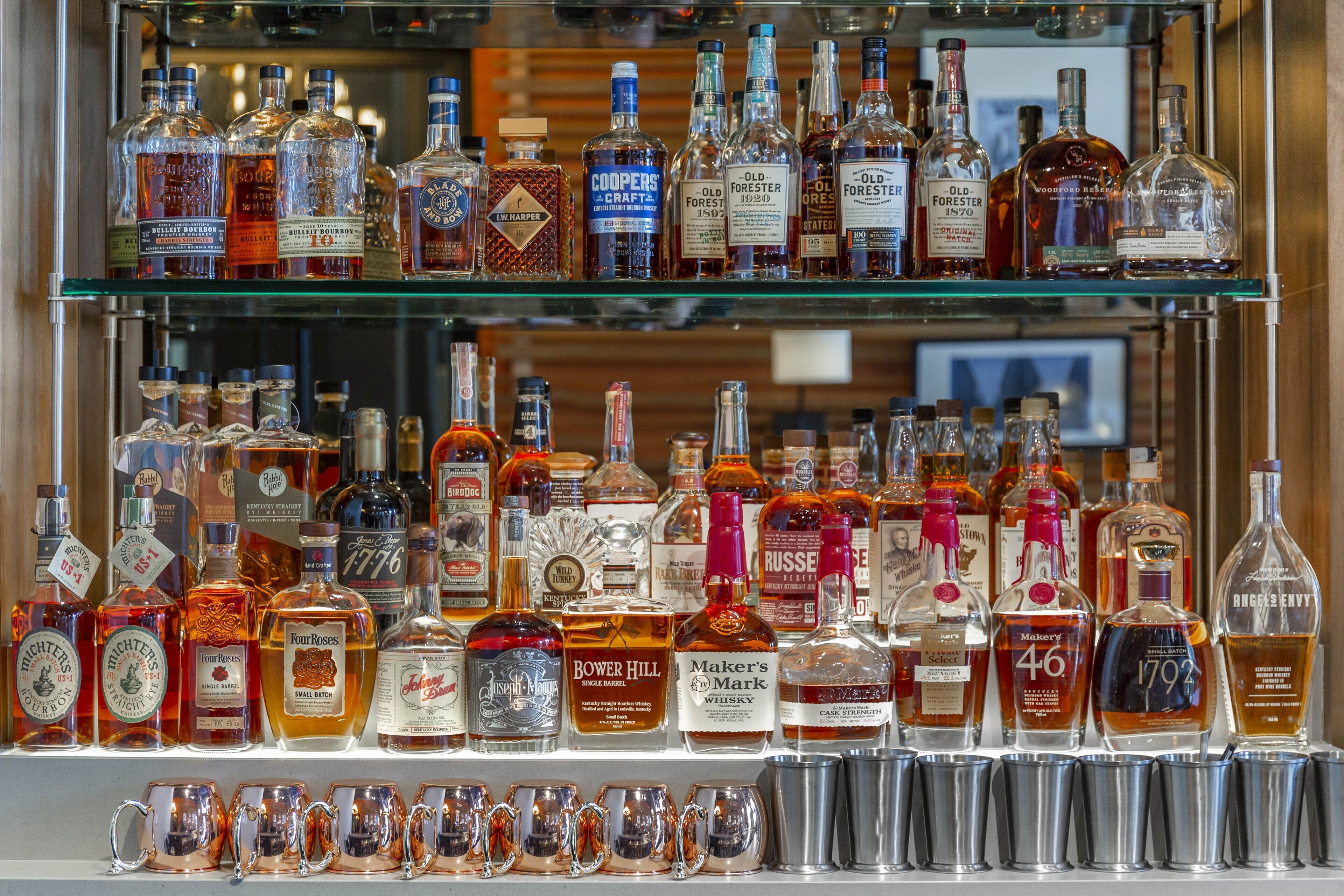 Variedad de botellas de licor en estantes.