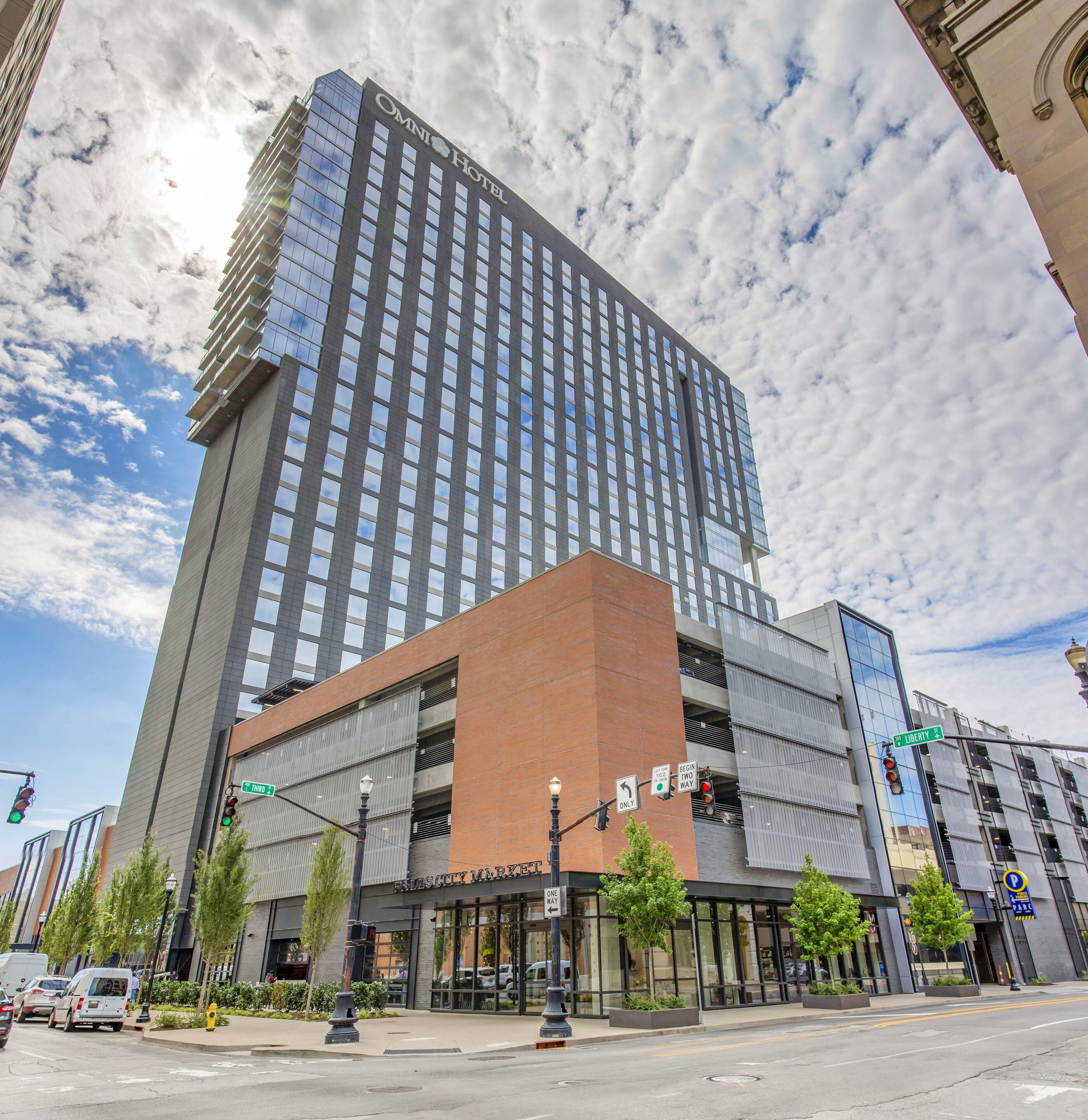 A modern hotel with a prominent Omni Hotel sign, a Liberty Street entrance, and a visible parking sign.