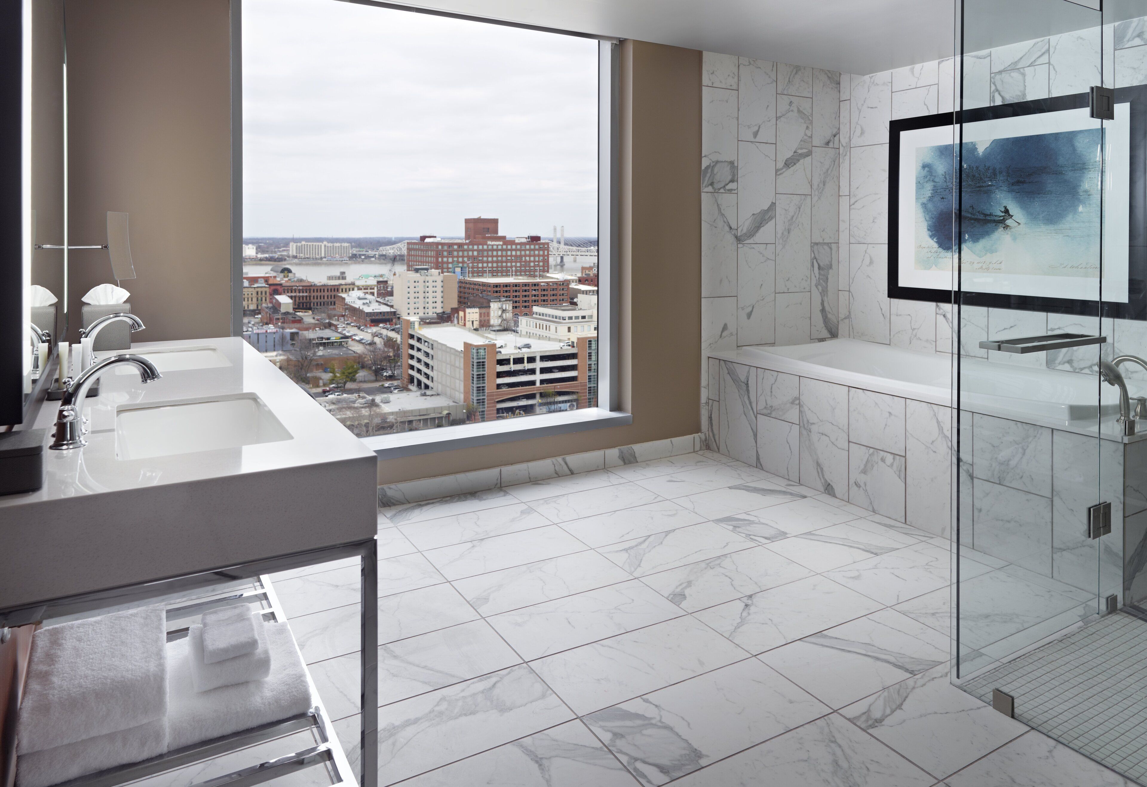 A modern bathroom with a large window, a bathtub, and a vanity with a sink.