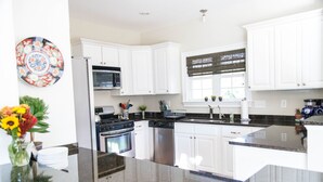 A modern kitchen with white cabinets, stainless steel appliances, and a granite countertop. - In the center of Nelson County's wine and beer region, 19 miles to UVA/Cville (Afton)