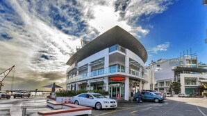 A modern hotel with a curved roof and multiple floors, featuring a prominent 'Wildfire' sign. - Premium 1BR Apartment at Princes Wharf (Auckland)