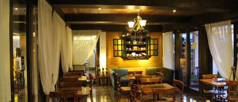 Un restaurante con muebles de madera, un candelabro y una barra con alimentos.