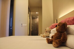 A hotel room with a bed, two teddy bears, and a pink pillow. - Room Space Bukit Bintang (Kuala Lumpur)
