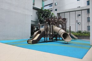 Children can play safely on the paved area with a slide and climbing frame.