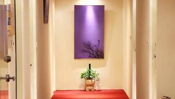 A hallway with a red carpet leading to a reception area.
