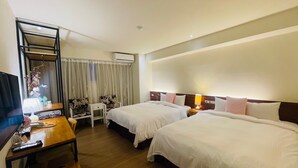 Quarto de hotel com duas camas, uma escrivaninha, uma cadeira, televisão e guarda-roupa.