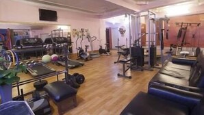 A gym with various exercise equipment, including treadmills, stationary bikes, and weight machines. - Hotel Samrat International (Patna)