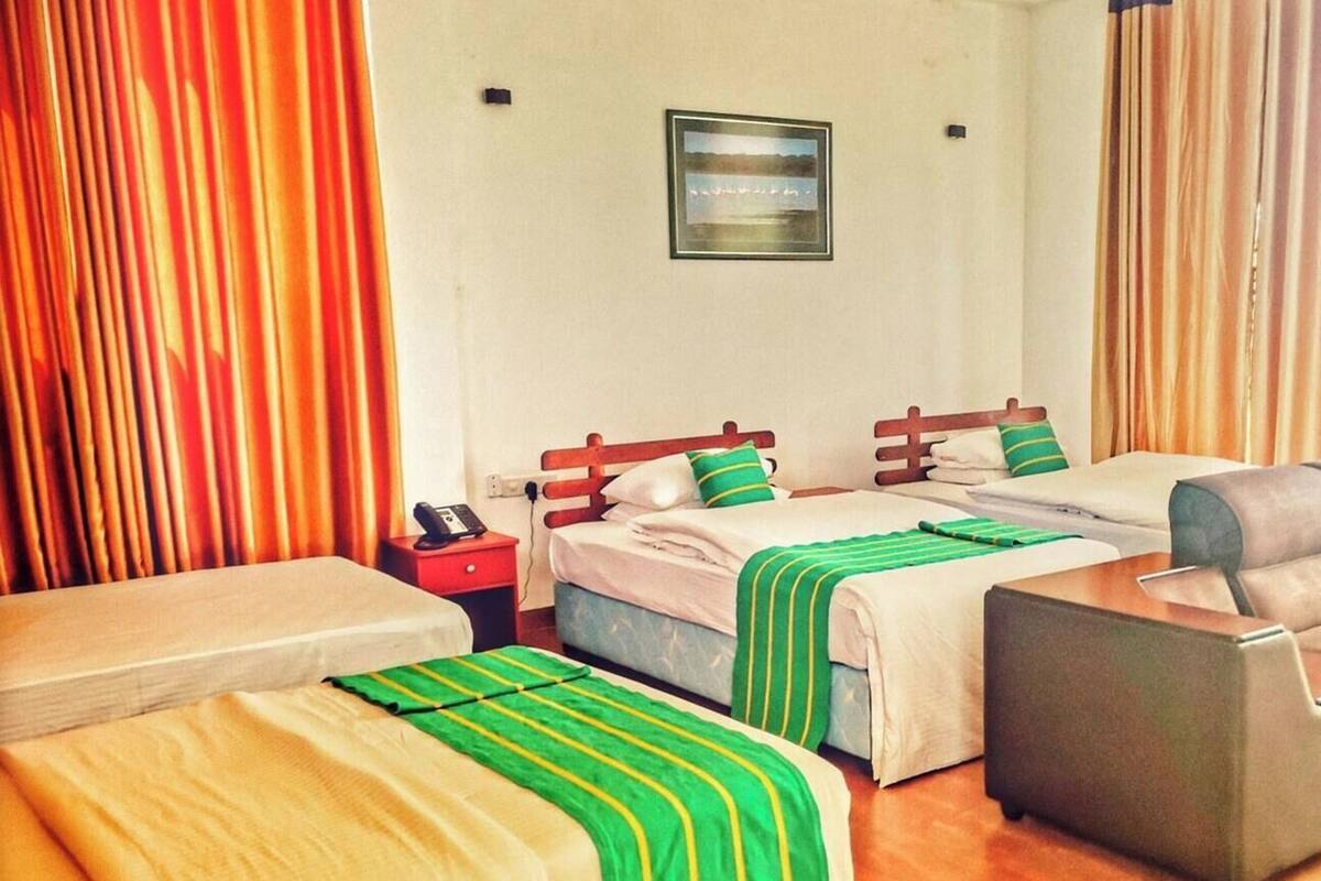 Een hotelkamer met twee bedden, een bureau, een stoel en een tafeltje.
