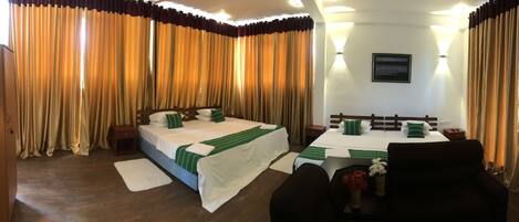 A hotel room with a bed, bedside tables, a desk, and a chair.