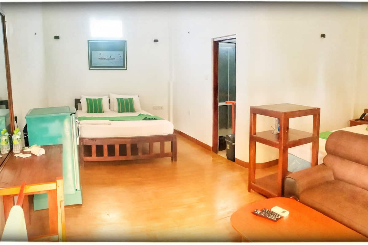 Een hotelkamer met een bed, een bank, een bijzettafeltje en een televisie.