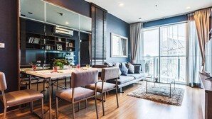 A modern living room with a dining area, a sofa, and a large window with curtains. - Bangkok Sky Walk (Bangkok)
