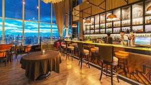 A bar area with a city view, wooden flooring, and bar stools. - Bangkok Sky Walk (Bangkok)
