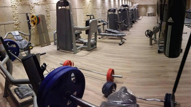 A gym with various exercise equipment, including weight machines and free weights. - Kremon Hotel (Usak)