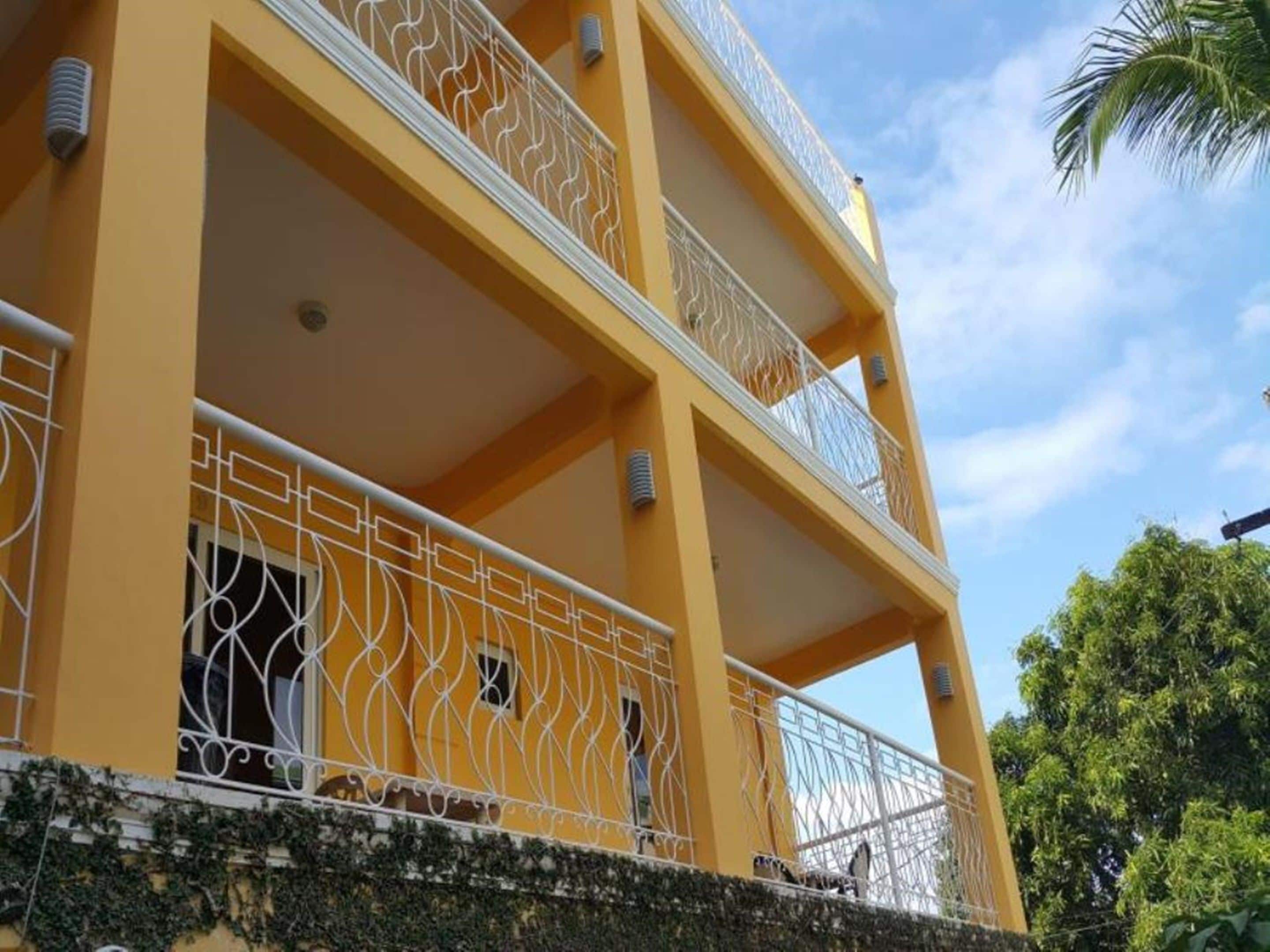 Un edificio de varios pisos con balcones y fachada amarilla.