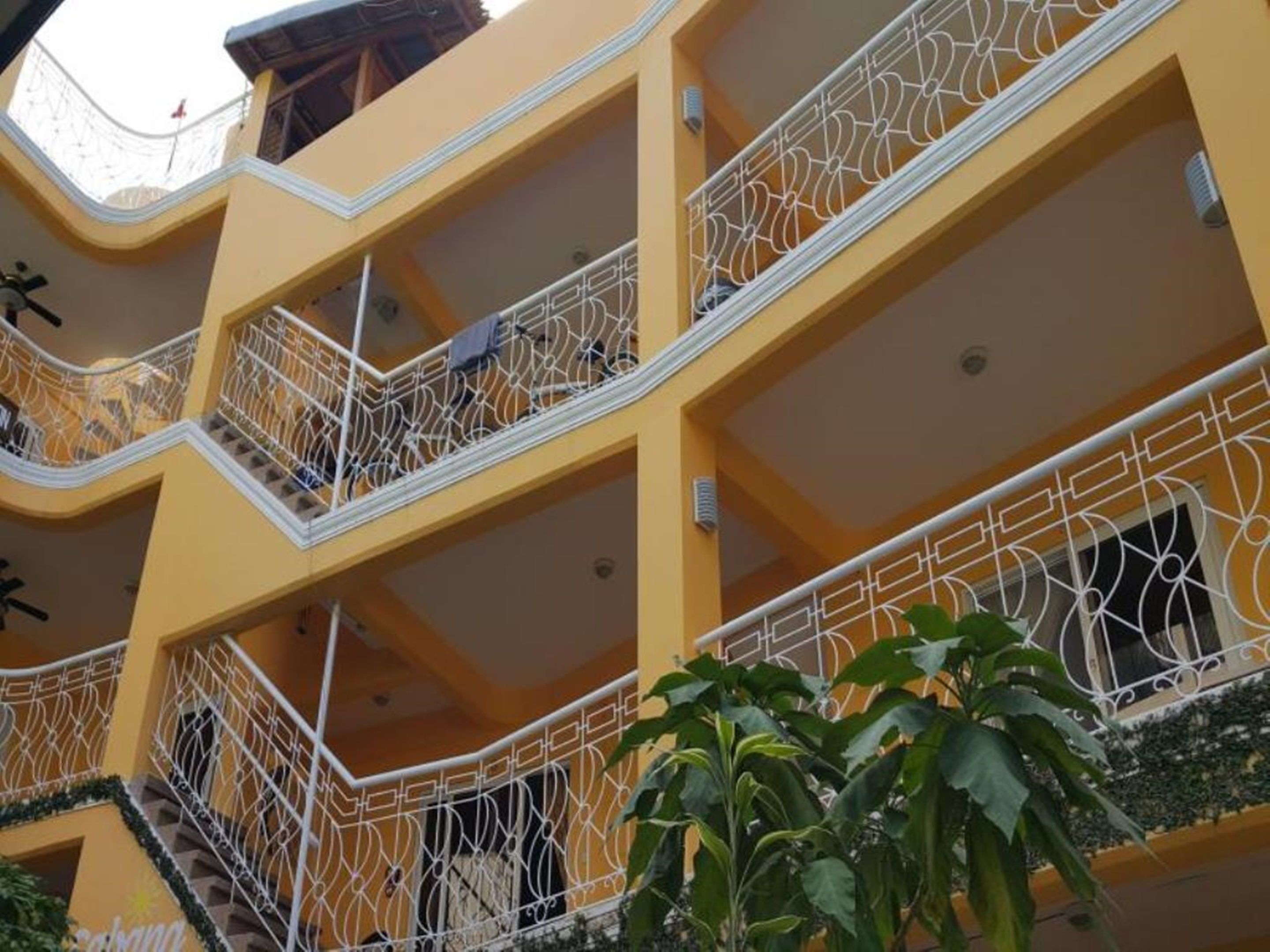 Un edificio de varios pisos con balcones, cada uno con barandillas blancas ornamentadas.