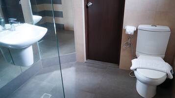 Un baño con inodoro, bidé y lavabo.