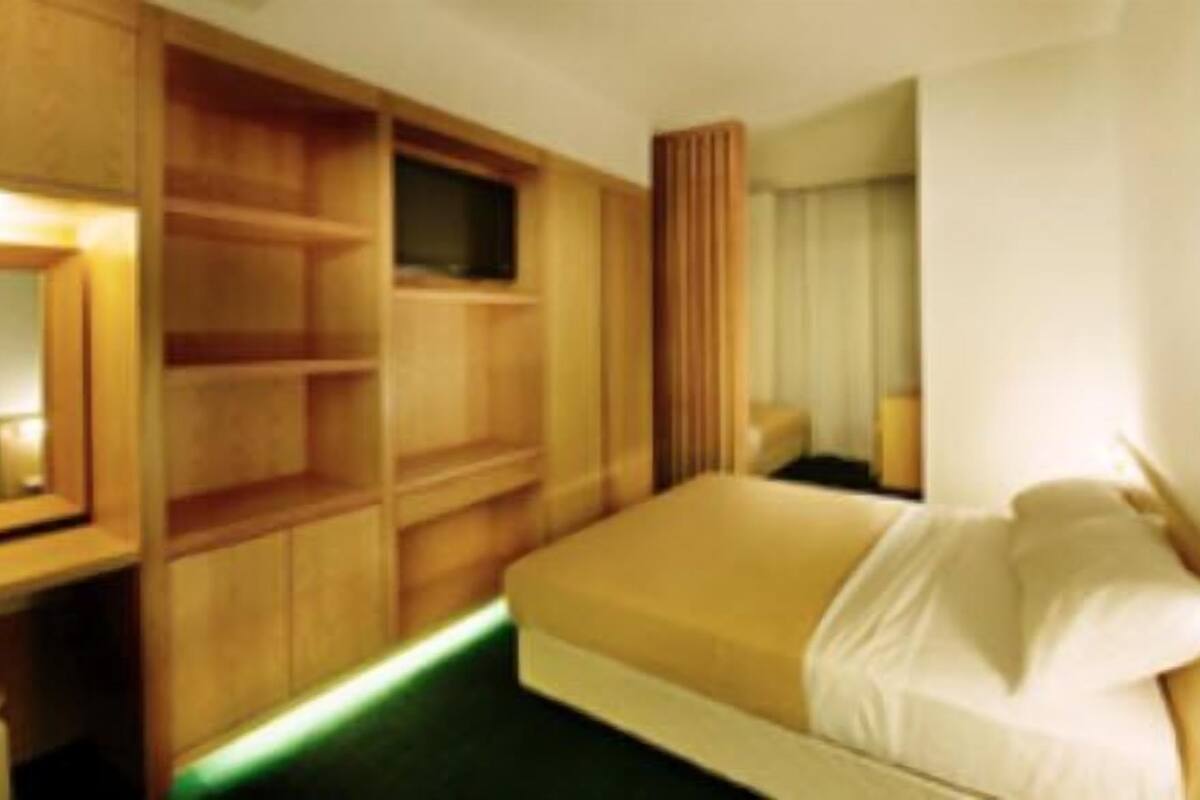 Una habitación de hotel con cama, escritorio y armario.
