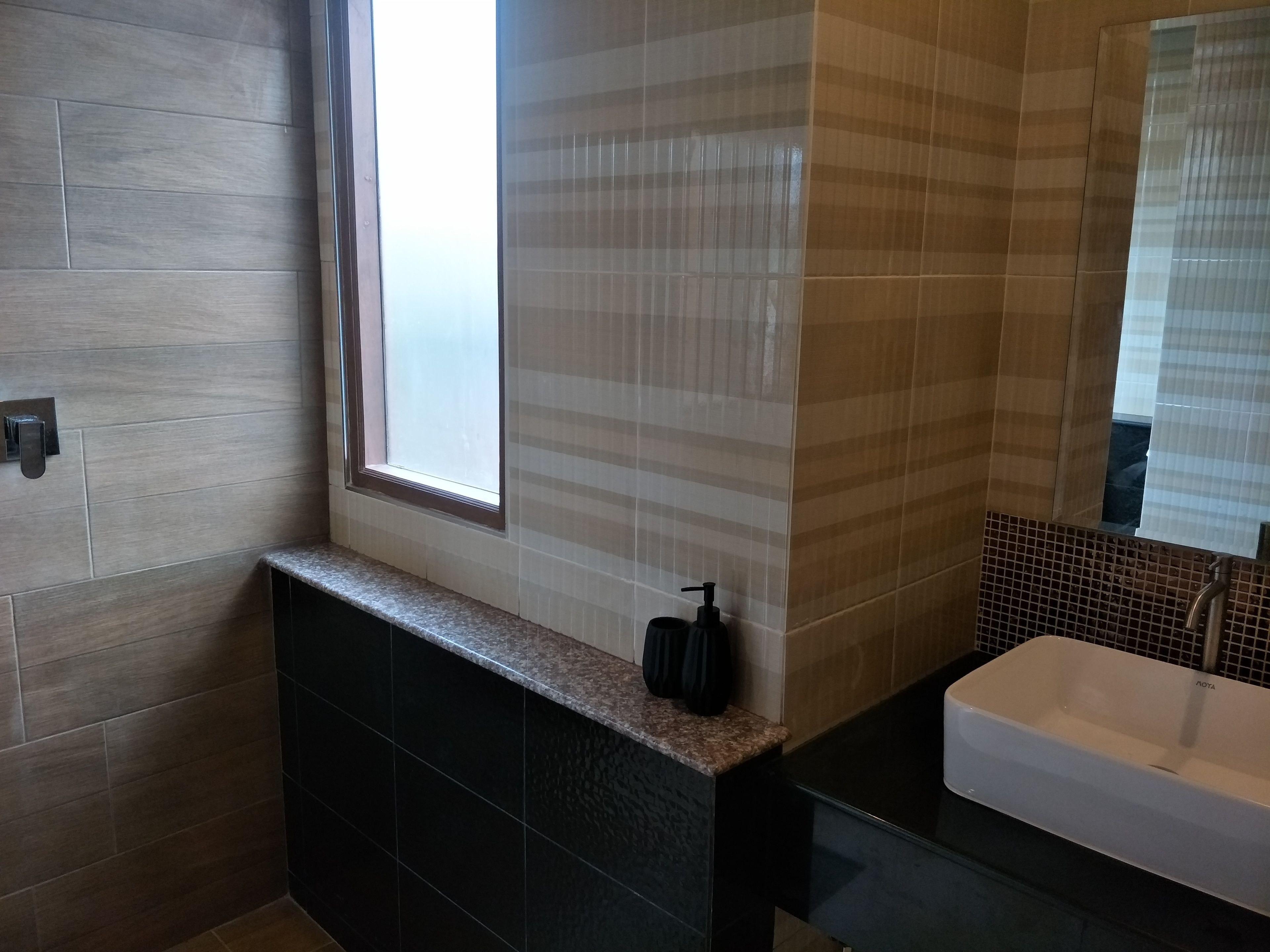 A bathroom with a bathtub, a window, and a sink.
