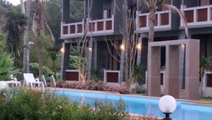 A pool area with lounge chairs and a bird. - Lanta Infinity Resort (Ko Lanta)