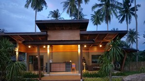 A modern building with a wooden facade, a reception desk, and a covered entrance. - Lanta Infinity Resort (Ko Lanta)