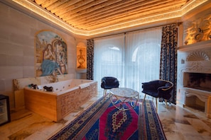 Relax in a spacious bathroom with a large bathtub, mirror, and decorative wall piece.