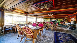 Enjoy meals in this elegant dining area with a large round table and wicker chairs.