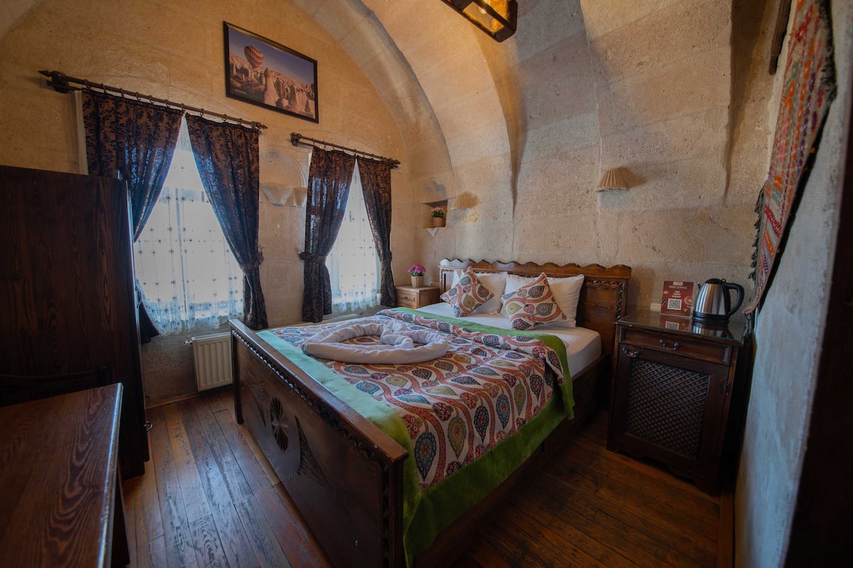 Um quarto acolhedor com uma cama de madeira, uma mesinha de cabeceira, um radiador e um pequeno armário.